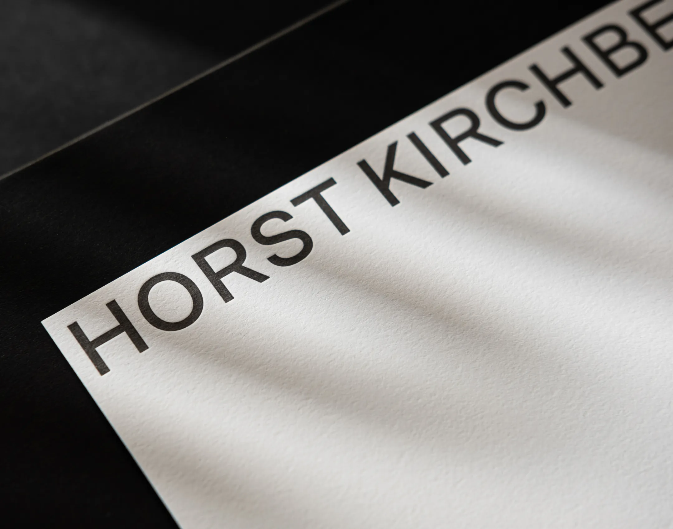 Detailaufnahme einer Visitenkarte: Wortmarke "horst Kirchberger" geprägt auf hochwertigem Papier