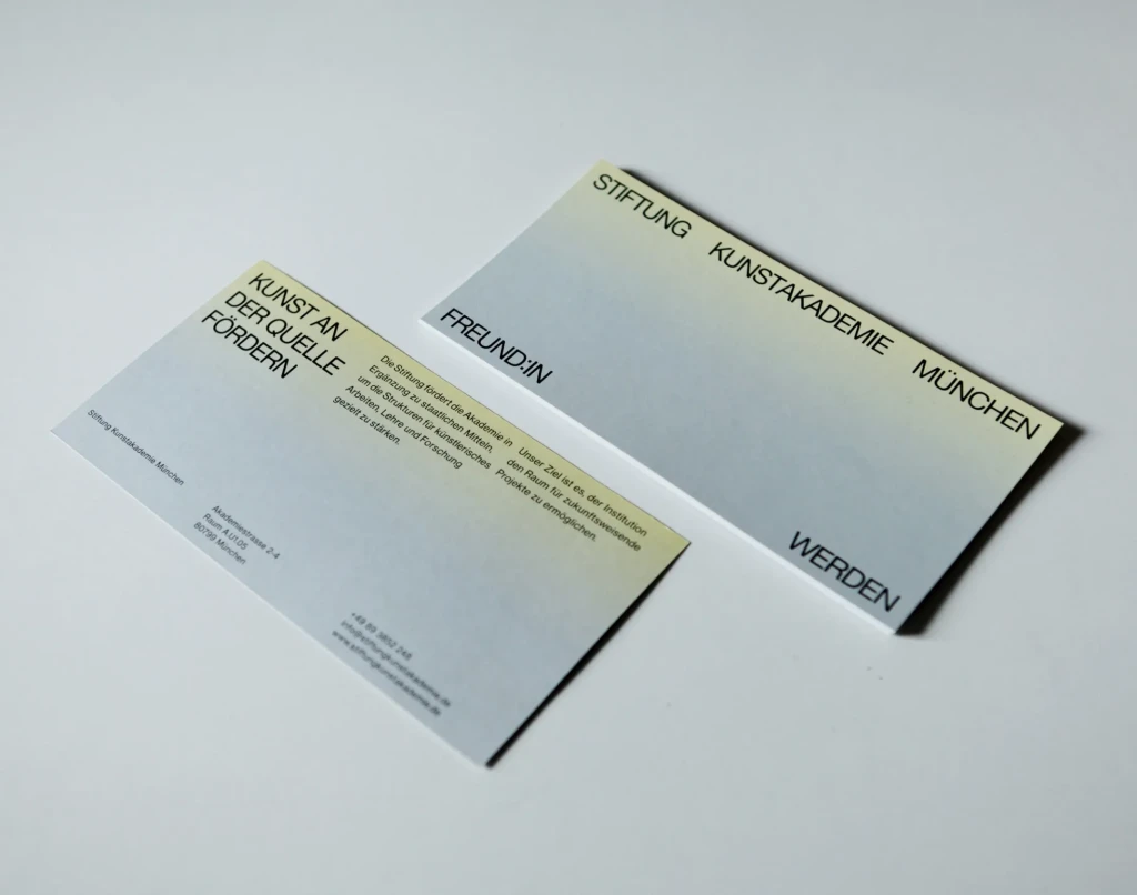 Infoflyer der Stiftung Kunstakademie München mit grau-gelbem Farbverlauf und Motto: Kunst an der Quelle fördern